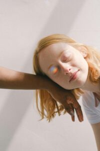 Woman with her eyes closed leaning on an arm. She is getting support from a mental health therapist.