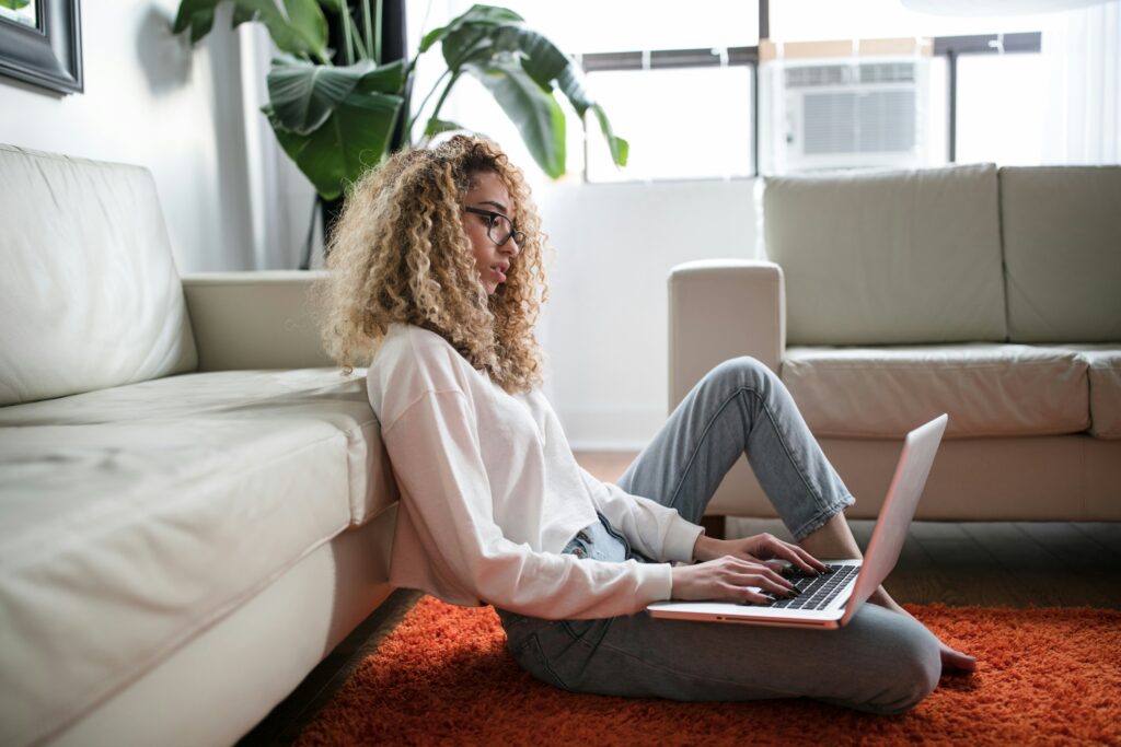 Woman sitting on the floor of her office, working on her computer. motherhood and careers do align with the help of Manhattan therapists focused on your mental health. Manhattan therapists offer 8 strategies to help.  