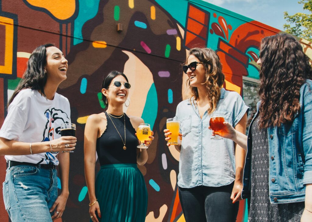 Group of women in Brooklyn enjoying connecting and drinks. How to be happy single starts with building meaningful connections in Brooklyn. 
