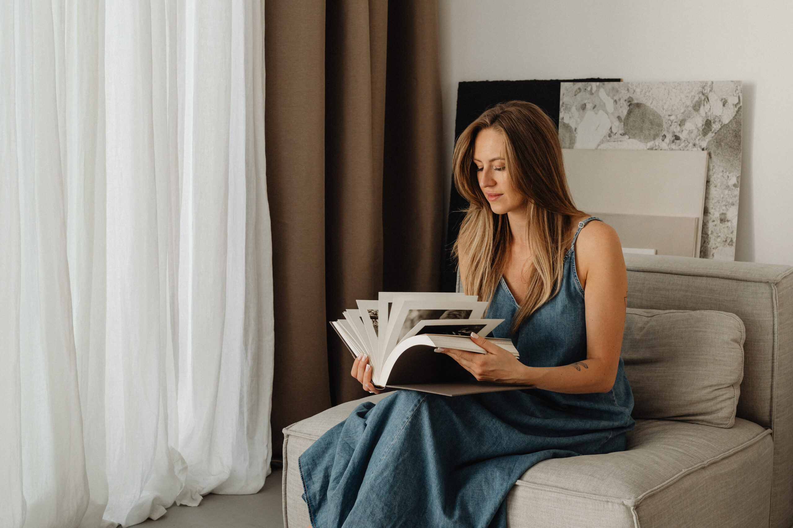Woman sitting on her bed with a blue dress on, flipping through a book. Eating disorder triggers are hard, but with these tips from Manhattan therapists, you can over them.