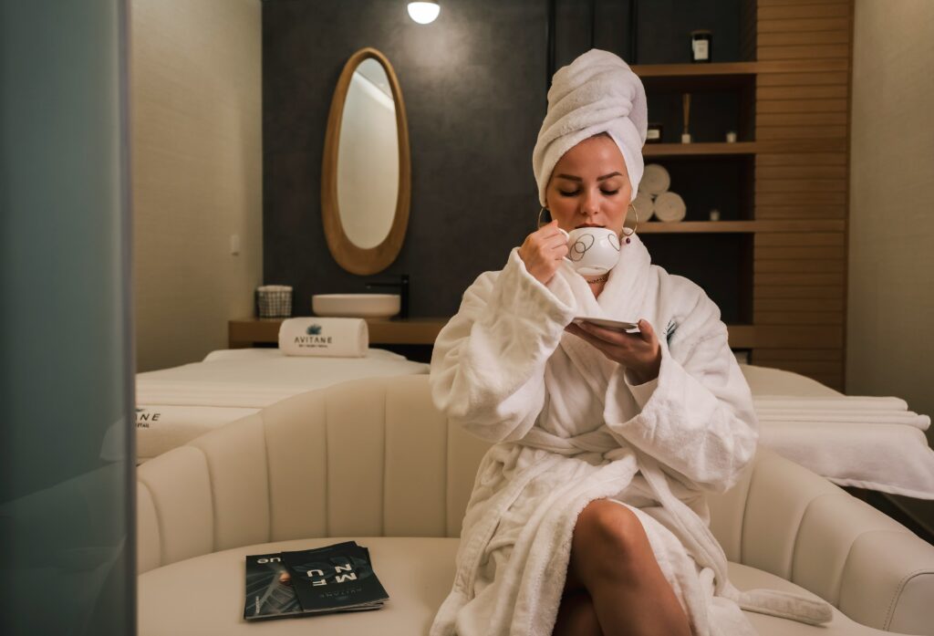 woman in a bathroom at a Manhattan spa with her hair wrapped up drinking a cup of coffee while she pampers herself. Self care is an important part of eating disorder recovery. 