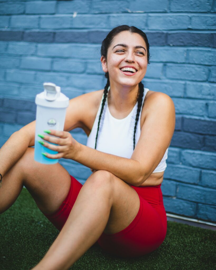Confident woman, having just completed a workout, drinking water. Therapy in Brooklyn can improve self confidence and self esteem. 