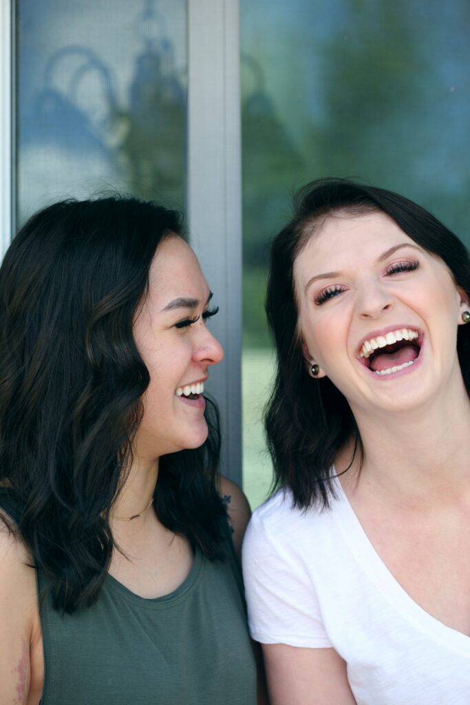 Two friends in Brooklyn smiling and laughing enjoying their relationship. Eating disorder recovery is better with support.