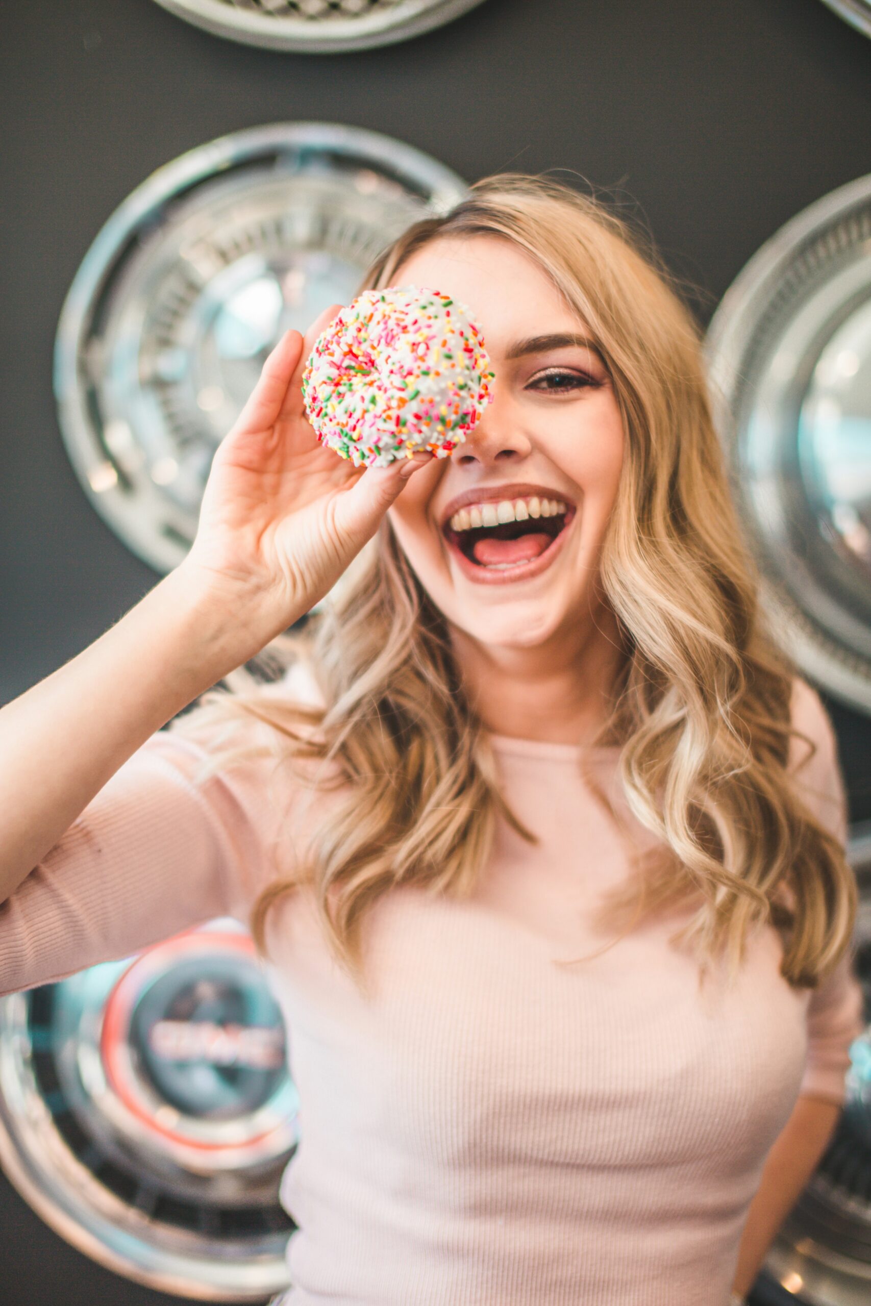 Manhattan woman smiling in a bakery holding a donut. She has overcome her black and white thinking.