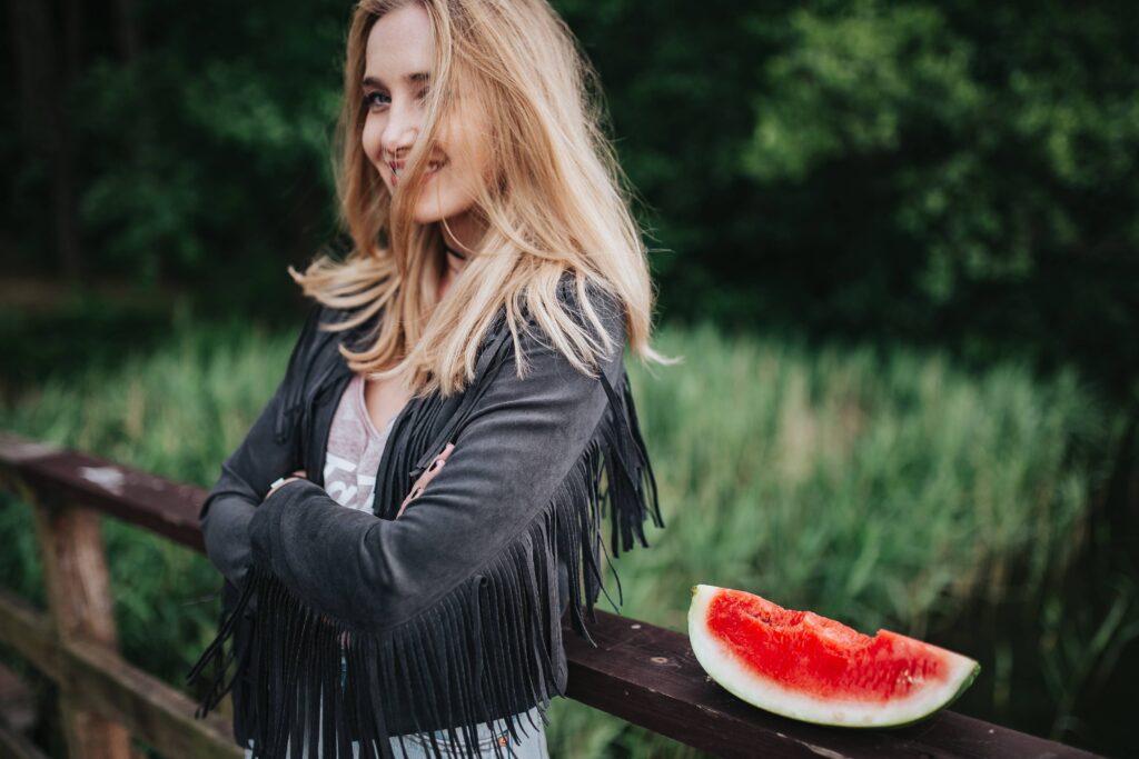 Woman smiling with a piece of fruit next to her. Depression and behavioral activation can help you. 