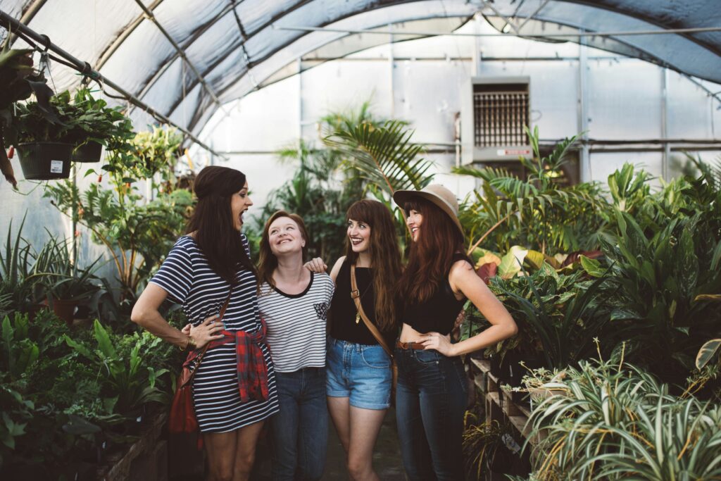 New York City friends handing out in a greenhouse. You can make friends quickly in Manhattan with these tips and tricks. 