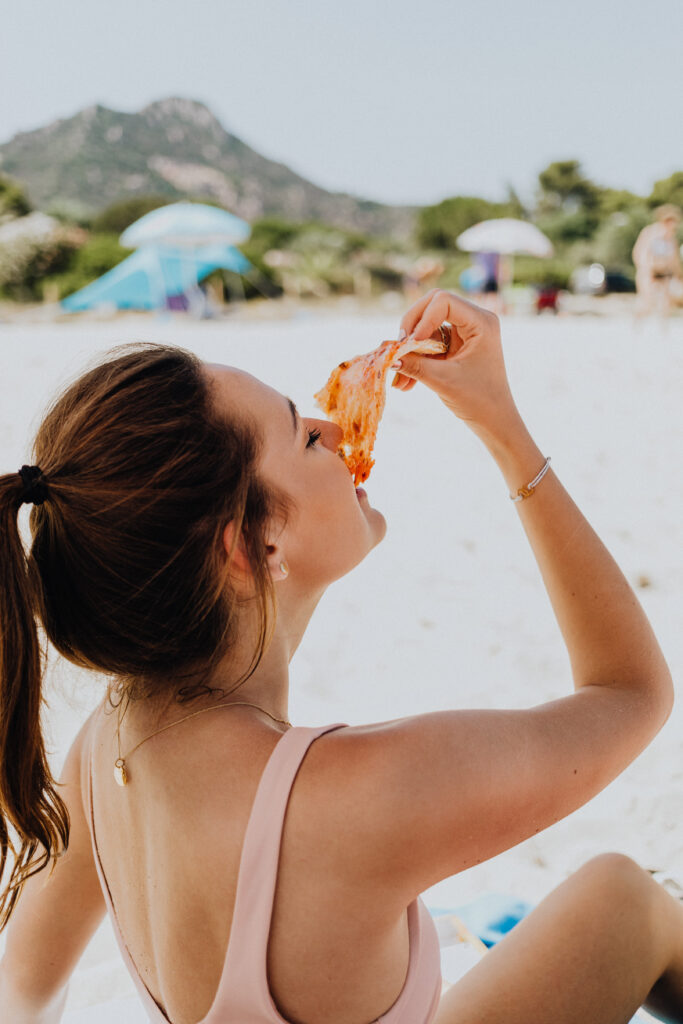 A New York City woman eating pizza after finding freedom from disordered eating. 