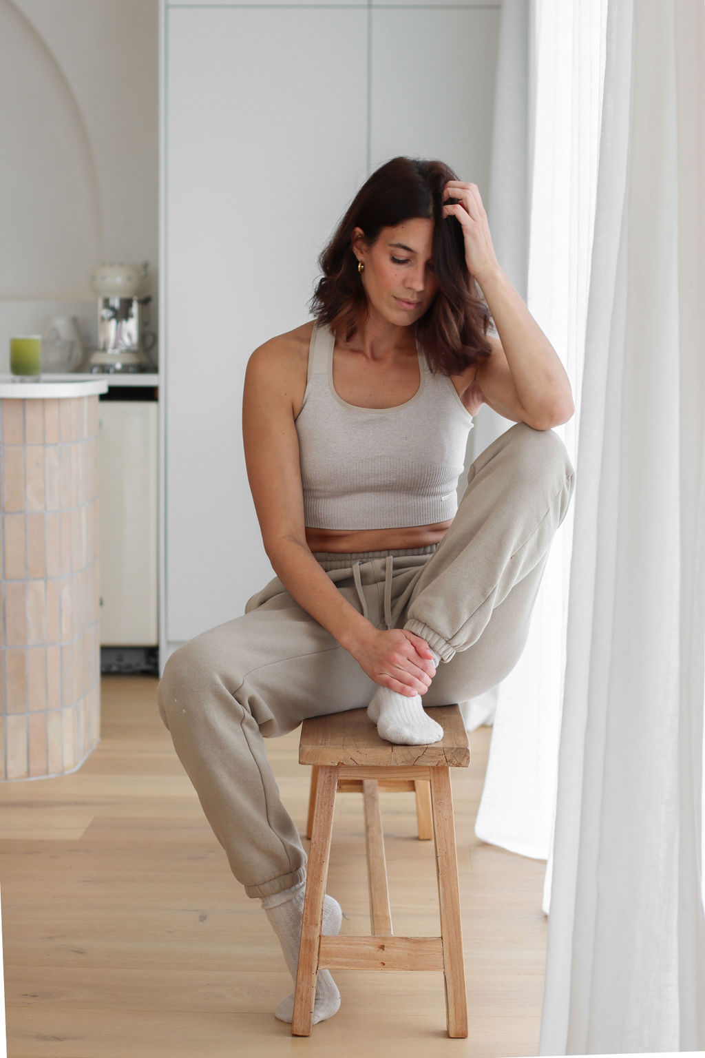 Brooklyn woman sitting on a stool in her apartment. Depression treatment can help.