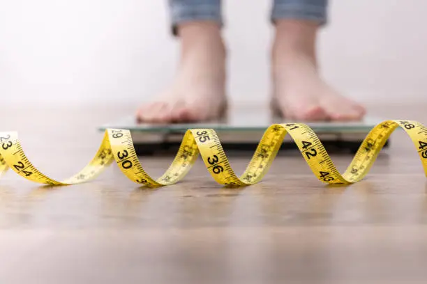 Feet standing on a scale. Finding freedom from an eating disorder is possible. Learn about all the types of EDs. 
