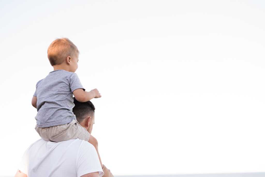 Manhattan dad with his toddler on his shoulders. Sometimes parenthood can be overwhelming. Therapy can help. 