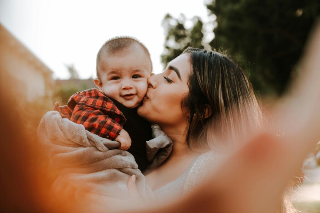 New mom kissing her baby's cheek. Becoming a mom can affect your mental health. 