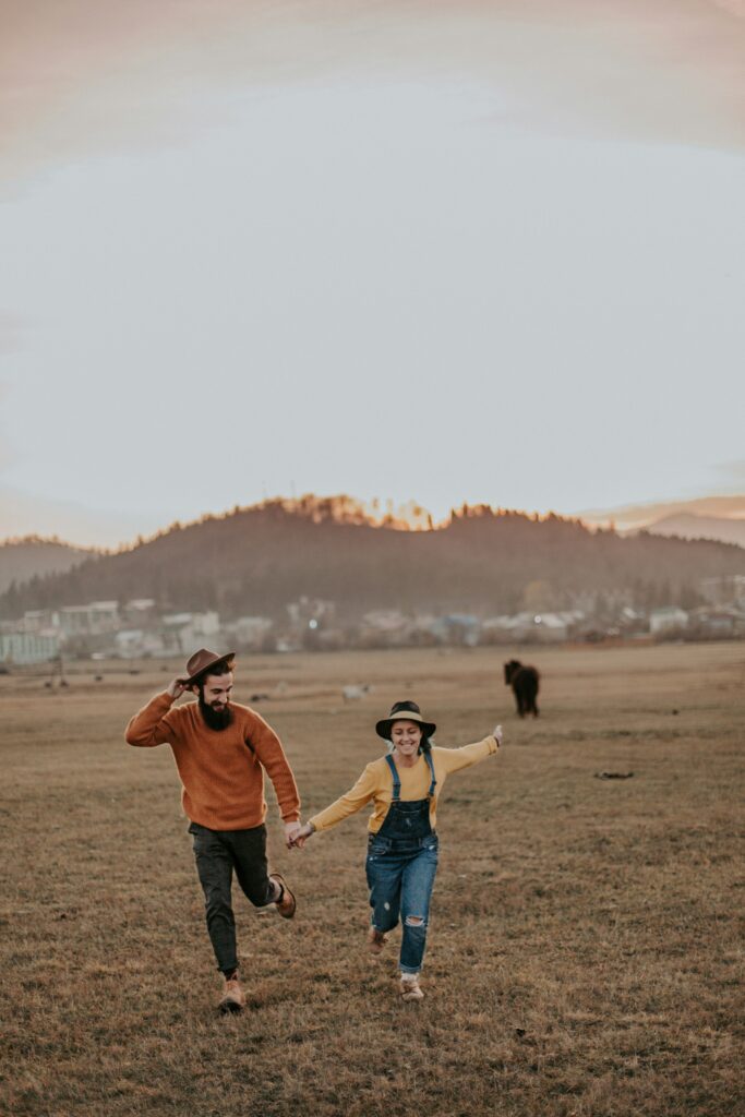 Brooklyn couple running through a field hand in hand. Communication is an important part of relationships and dating. 