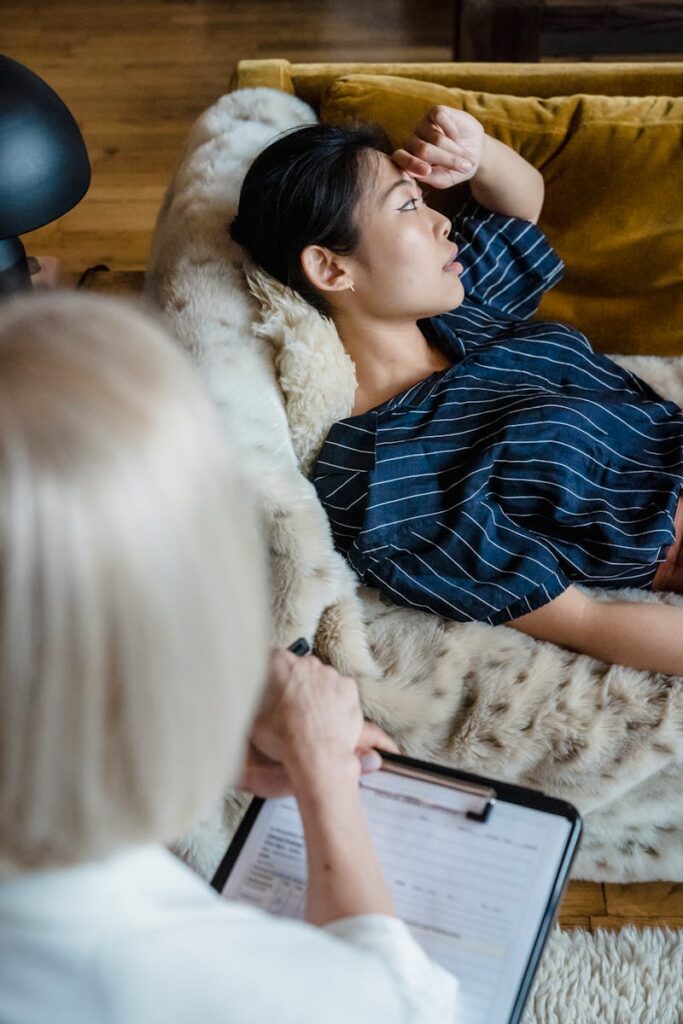 Female in therapy session laying on couch thinking.