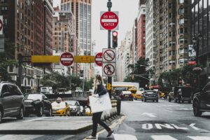 New York City woman shopping in Manhattan, carrying her bags across an intersection. Trauma and body image go hand in hand. Therapy can help.