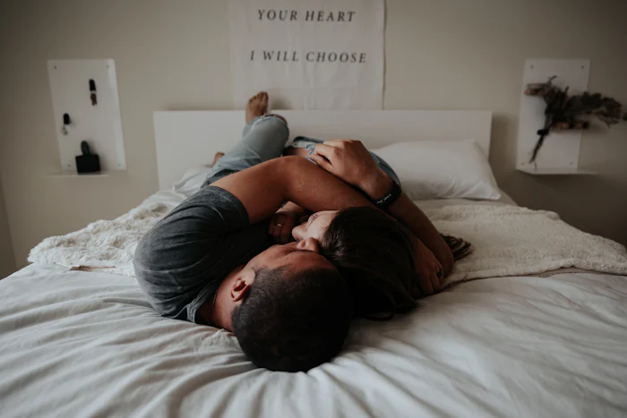 Couple laying in bed together hugging.