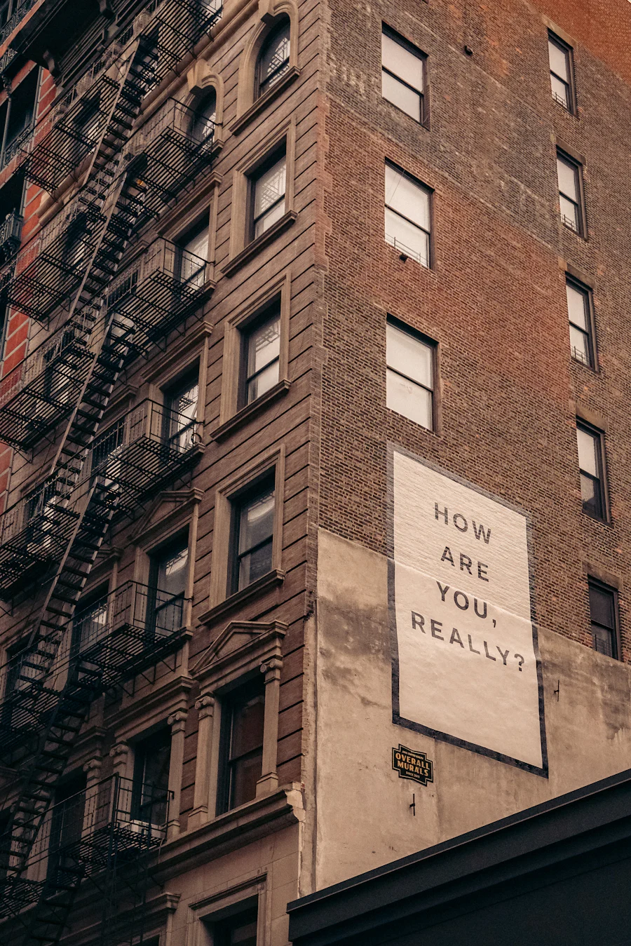 "How are you, really?" written on a brick building.