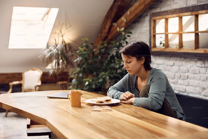 Woman starting at her plate of food.