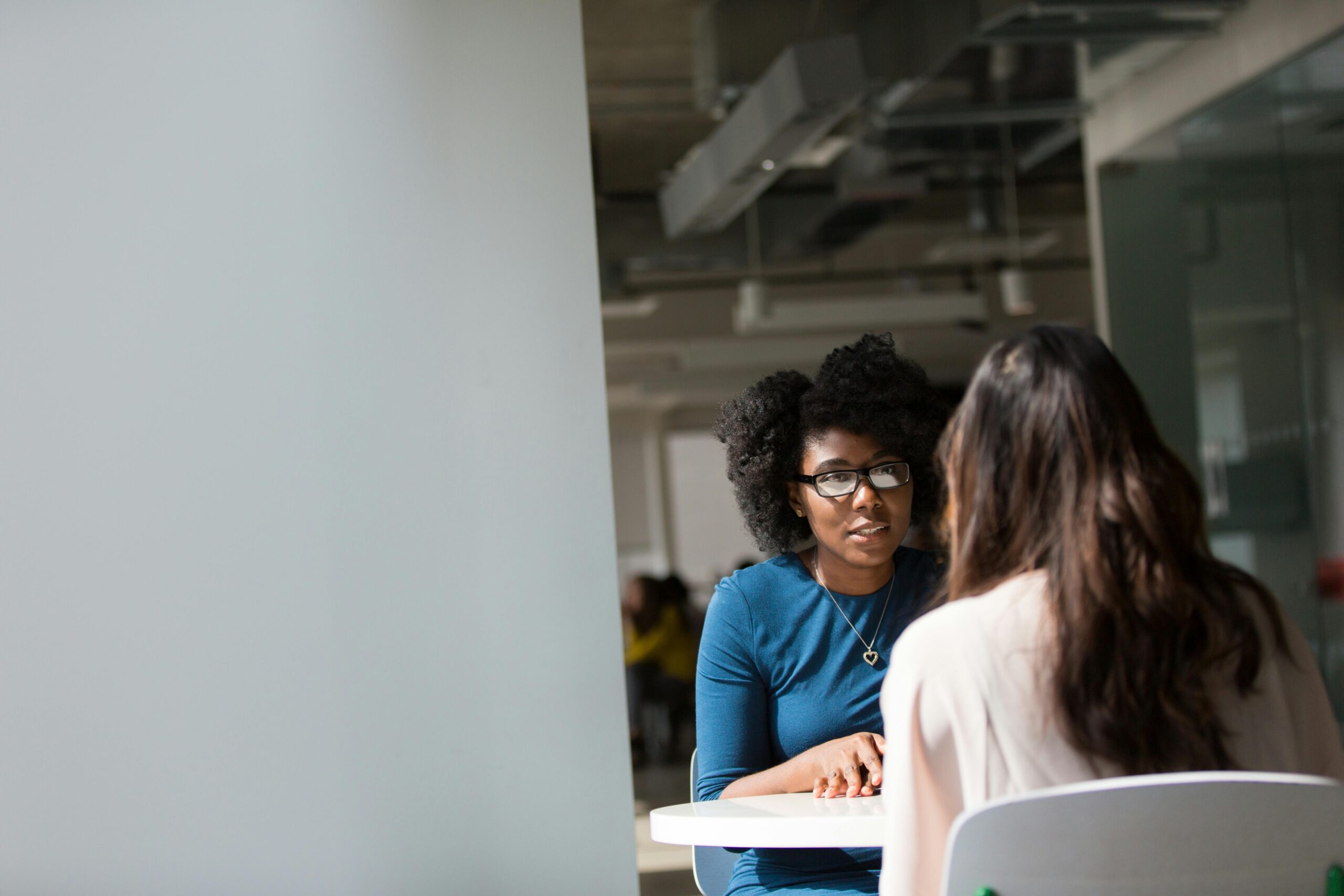 Therapist talking to client at a table.