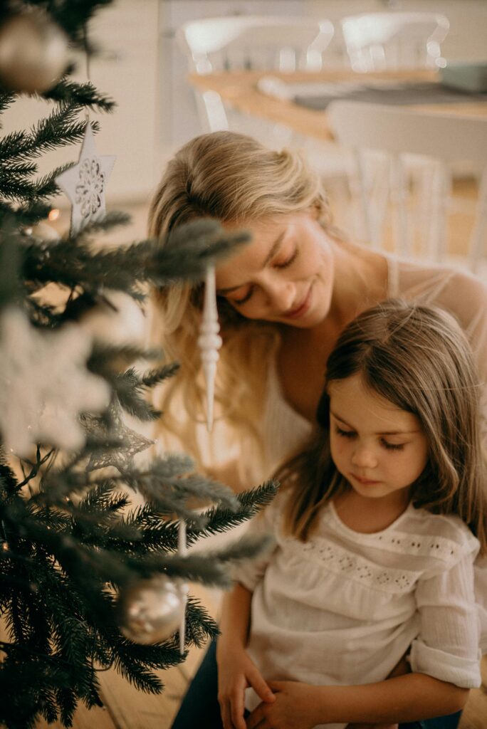 Mother and daughter in front of the Christmas tree together.