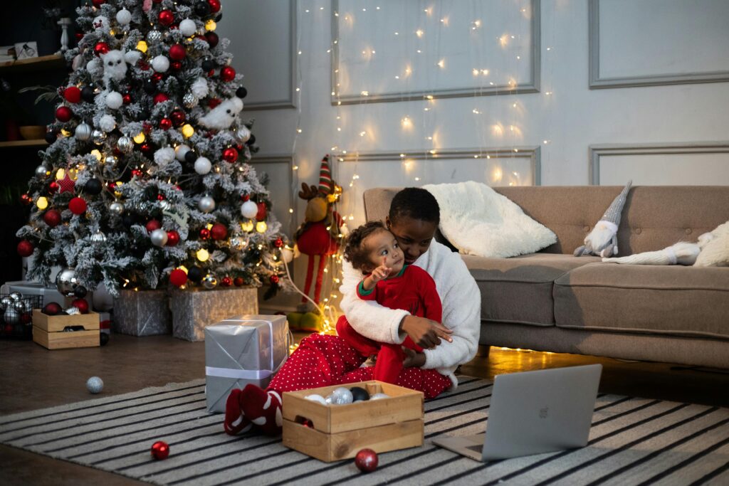 Parent and child together in front of Christmas tree on the computer.