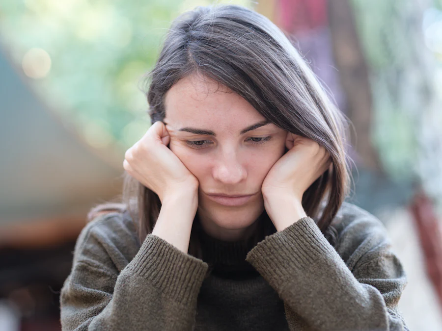 Woman looking tired and anxious, holding her face.