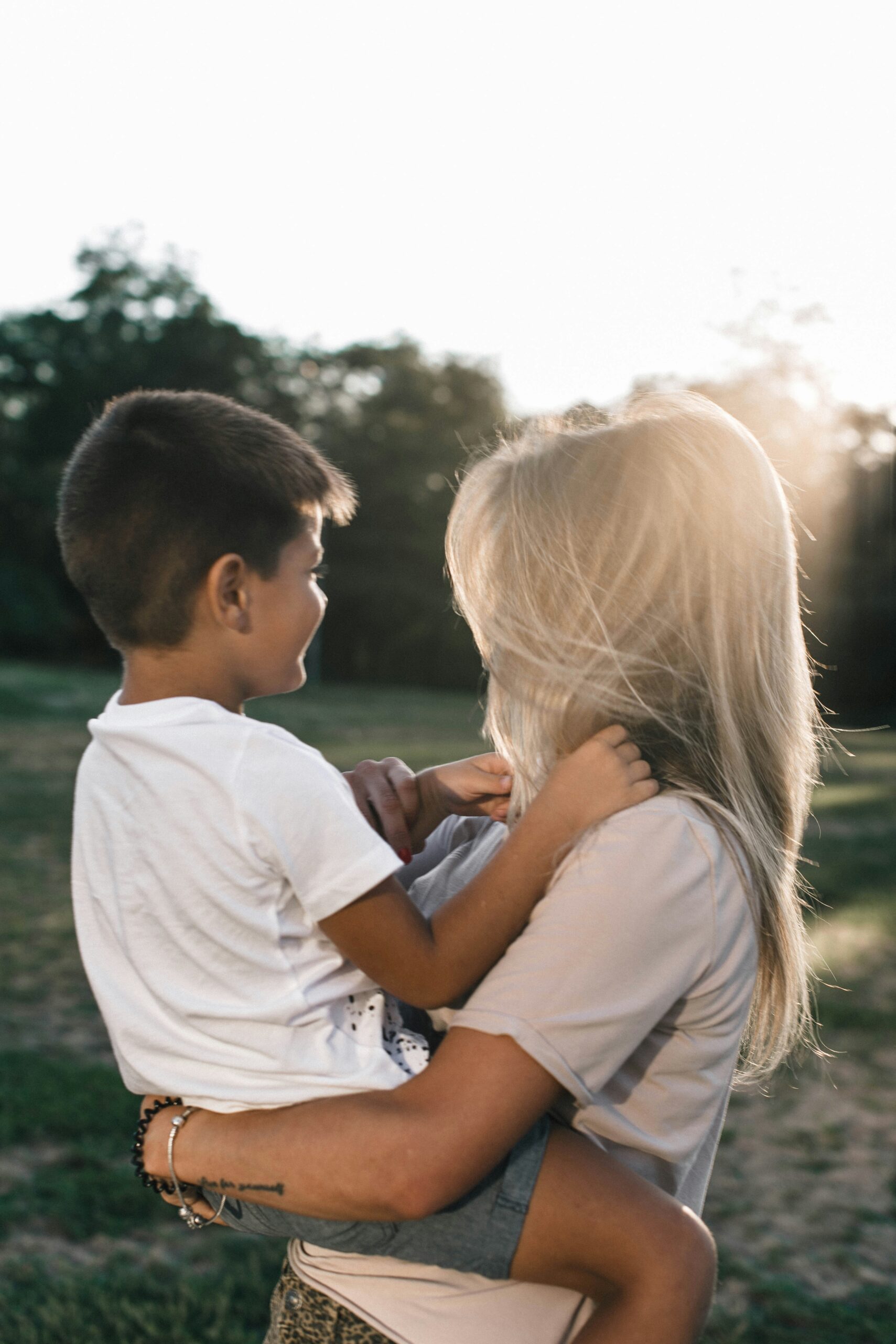 Mom holding her son outside together.