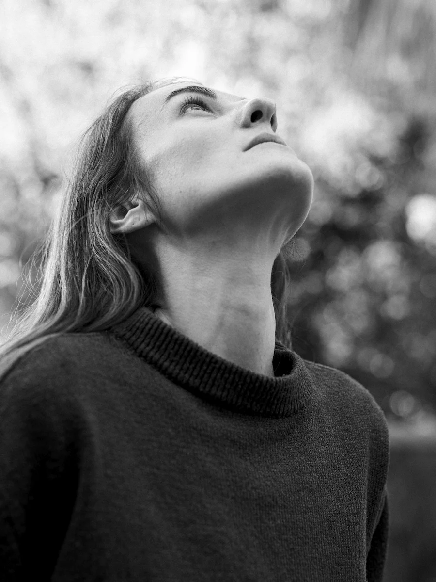 Black and white image of woman looking up.