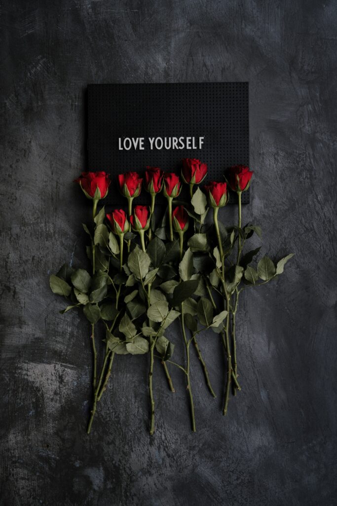 Love yourself paper and red roses.