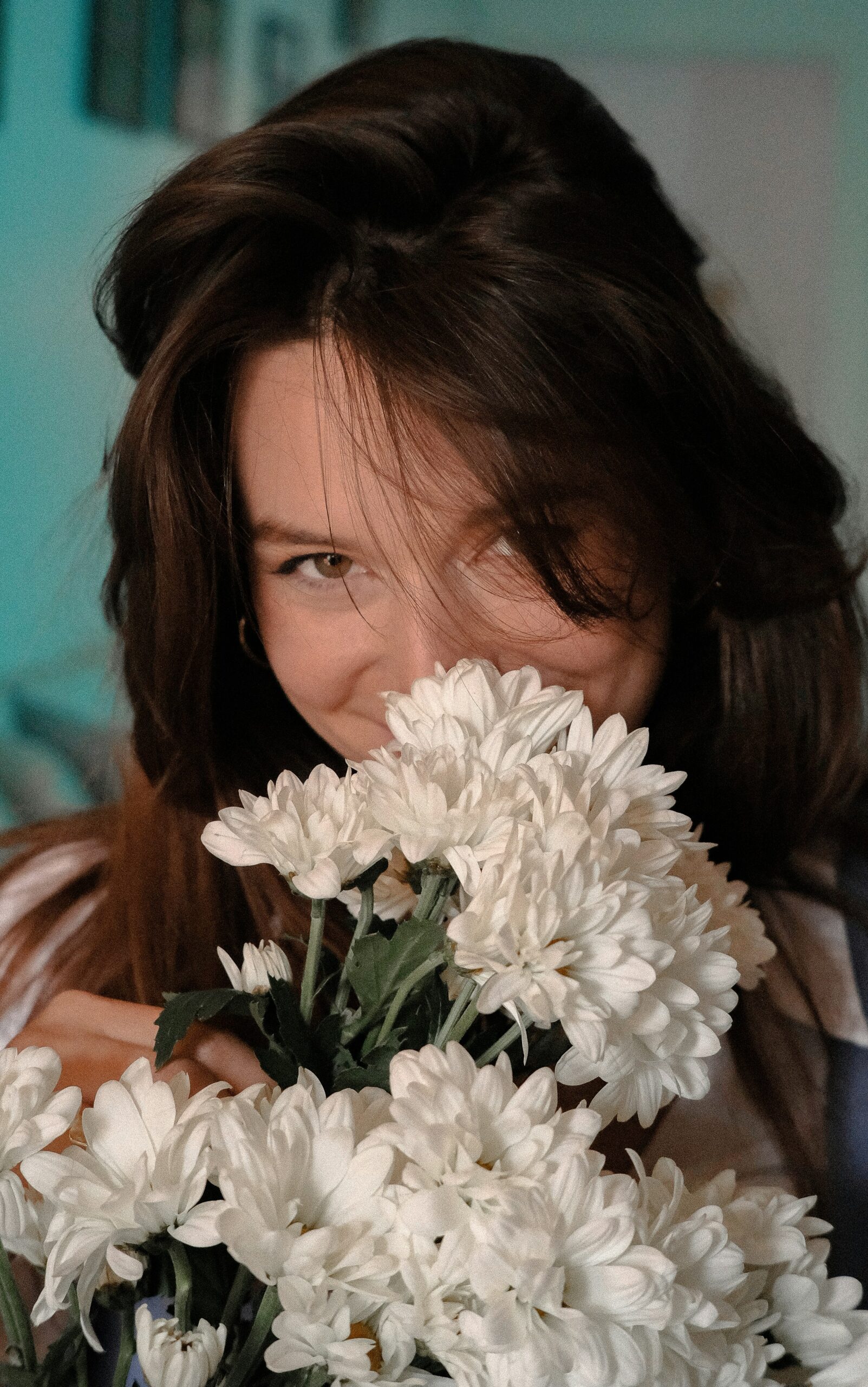 Woman smiling and smelling flowers.