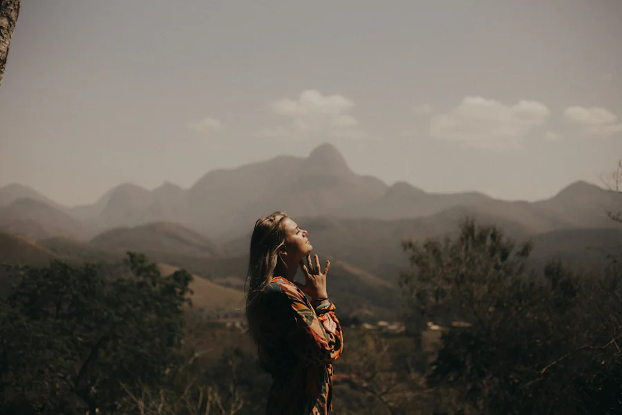 Woman standing on a mounting breathing and thinking.