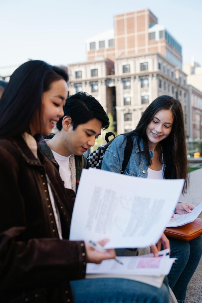 Three friends doing school work outside together.