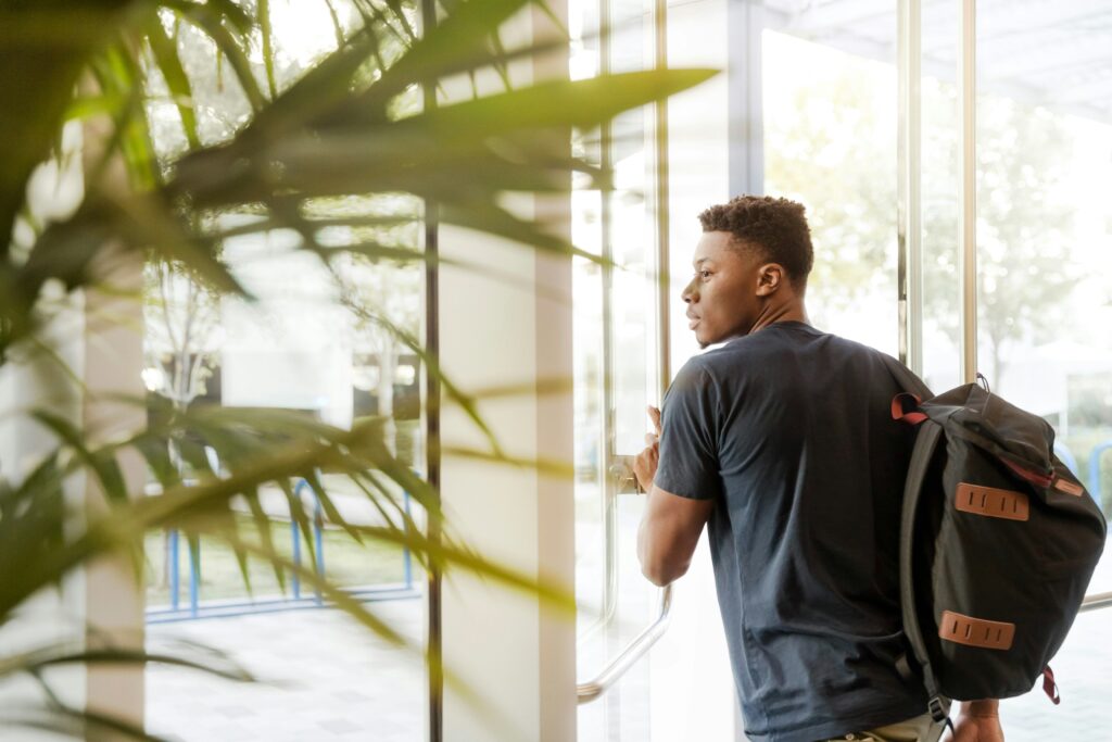 Male student walking through the door.