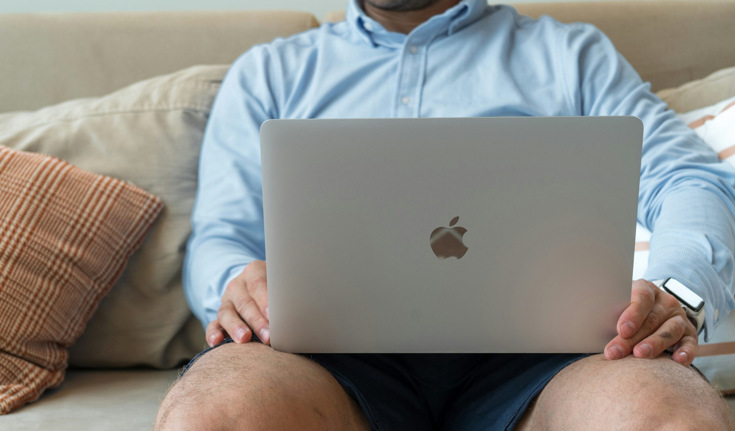 Man sitting on his couch on his computer.