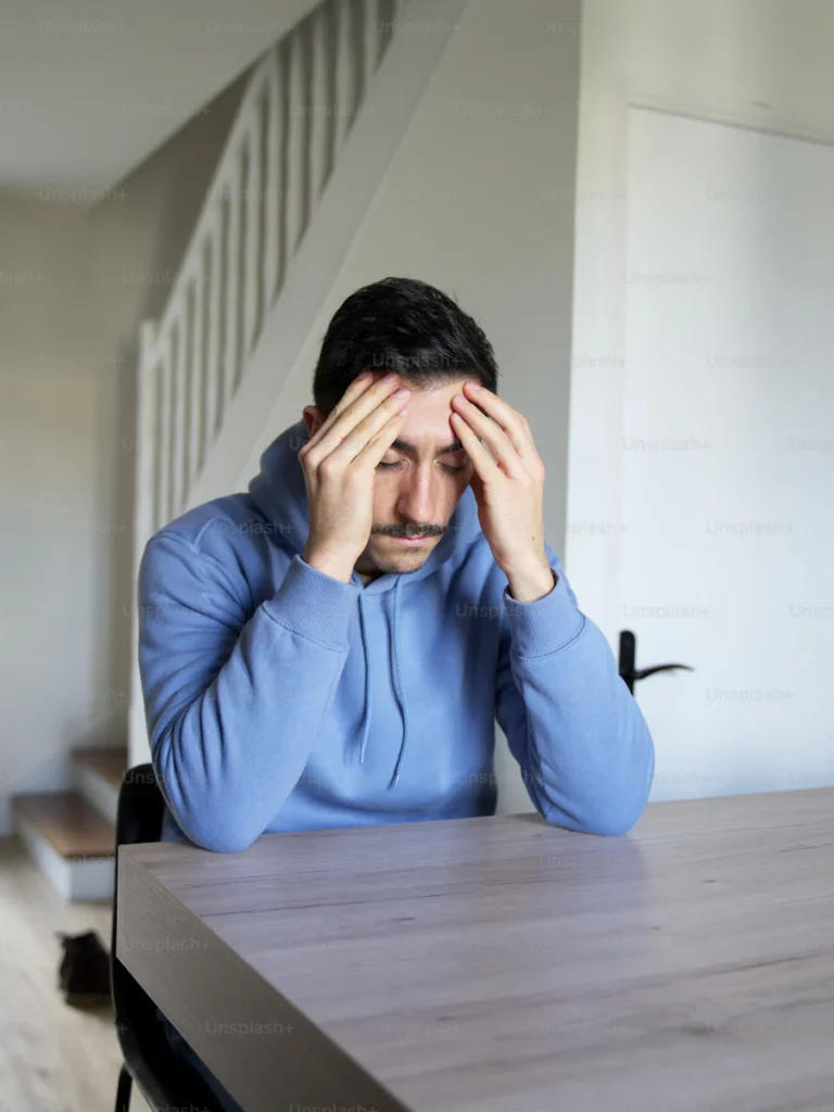 Stressed man sitting at a table.