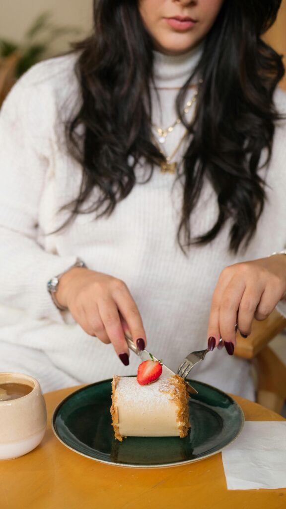 Woman cutting into her dessert on plate