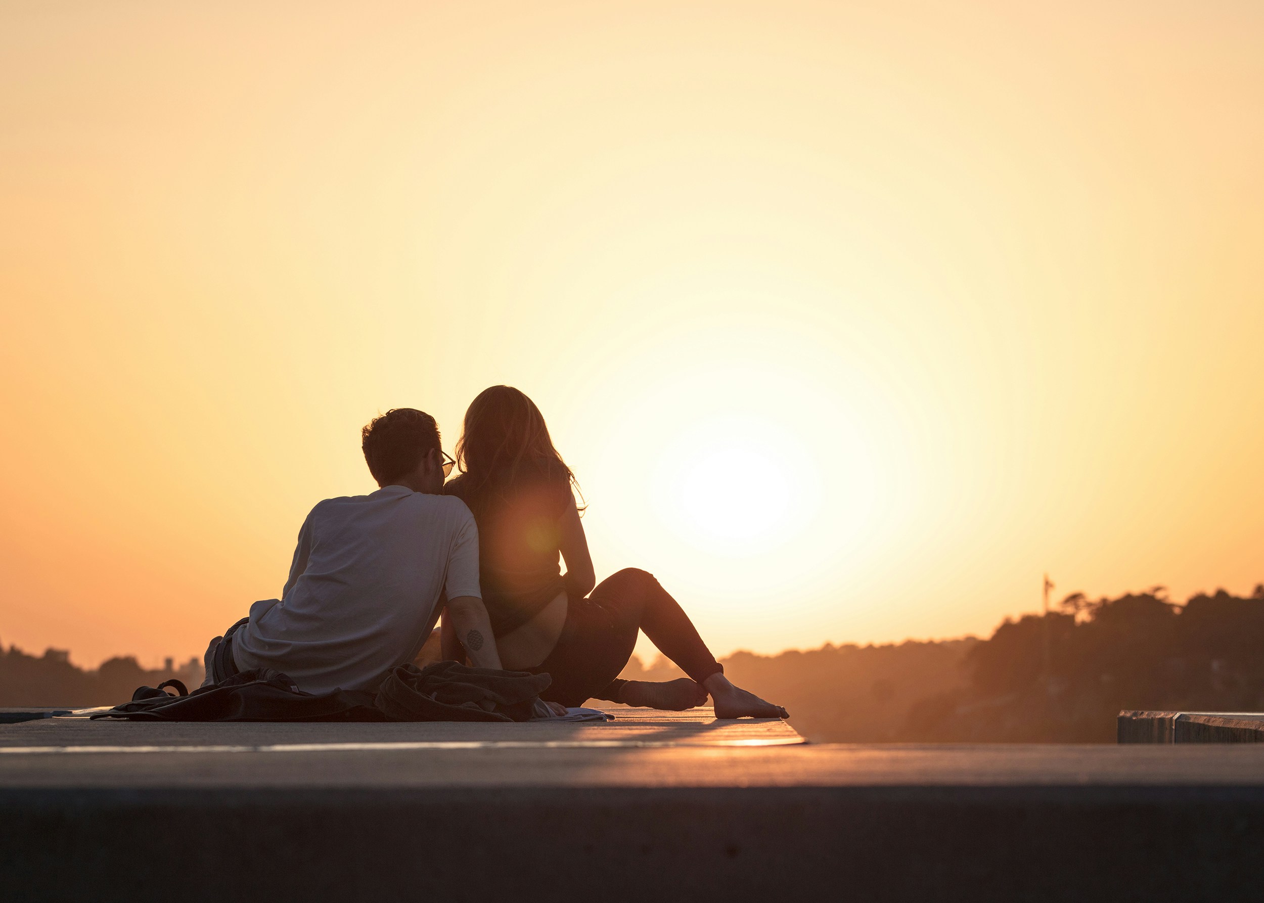 Couple sitting together in the sunset.