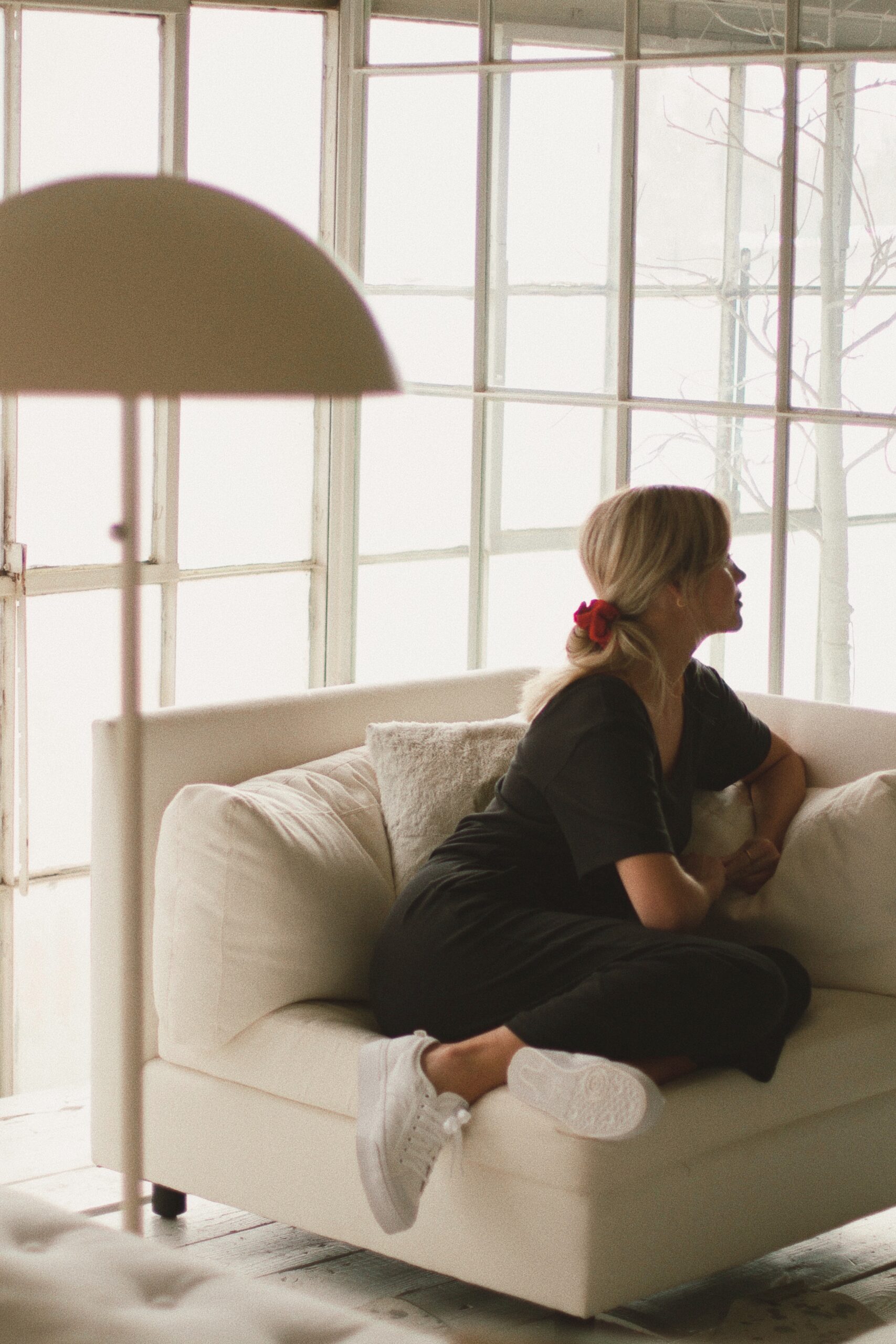 Woman sitting on the couch looking out the window.