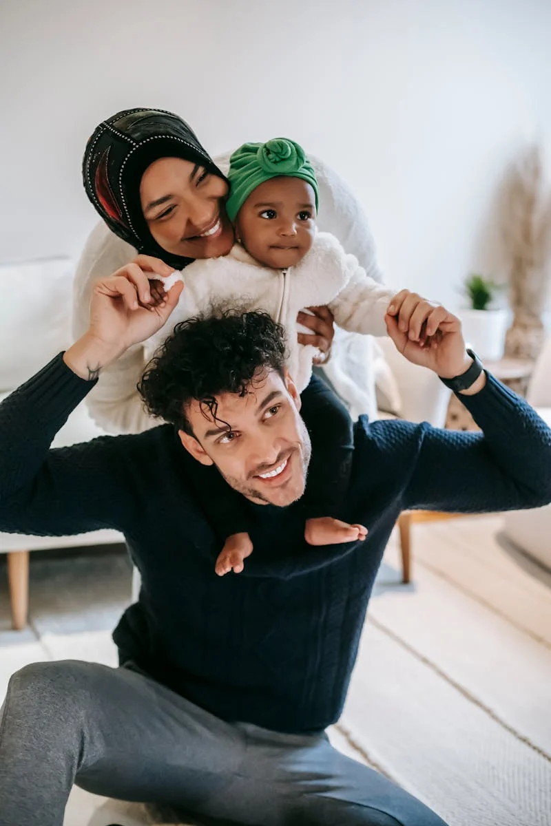 Mom, dad, and daughter playing and smiling together.