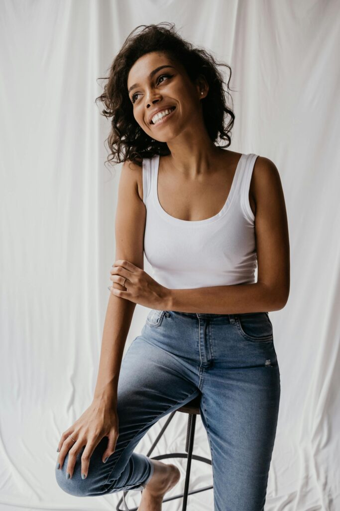 Woman smiling sitting on a stool.