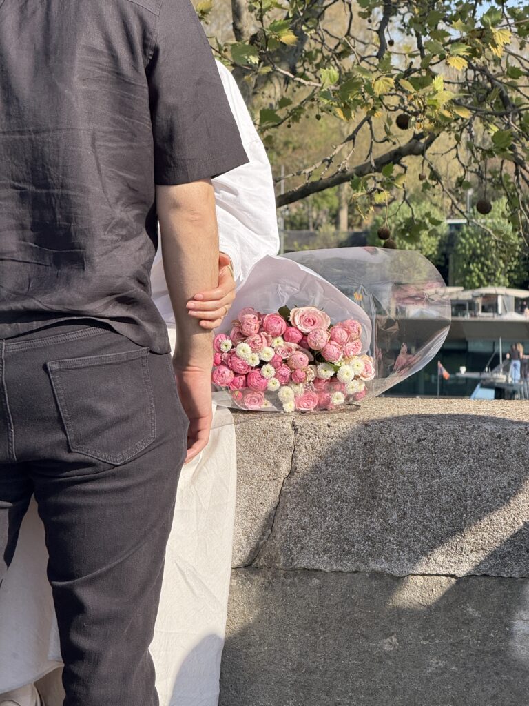 Couple outside, holding flower bouqet.