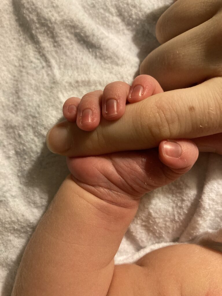Baby grabbing finger of a parent.