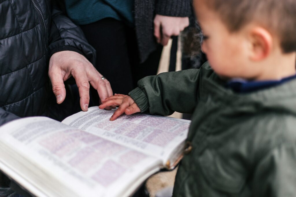 Child reading a book with parent.