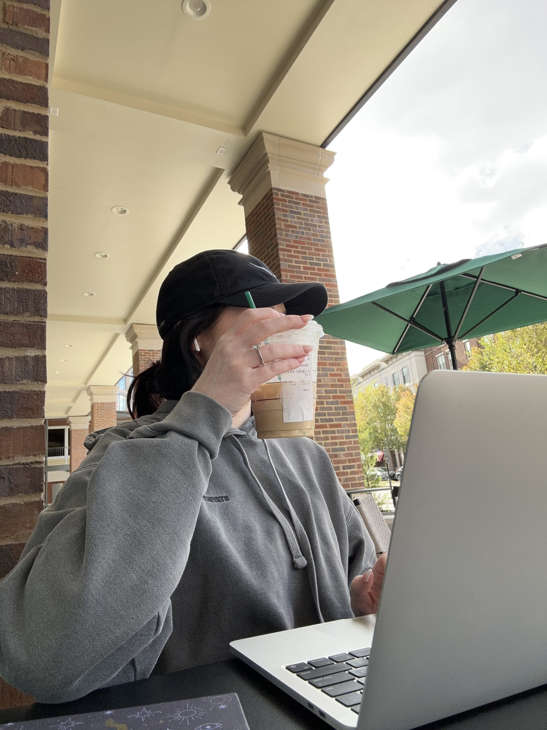 Female student drinking coffee and on her computer.