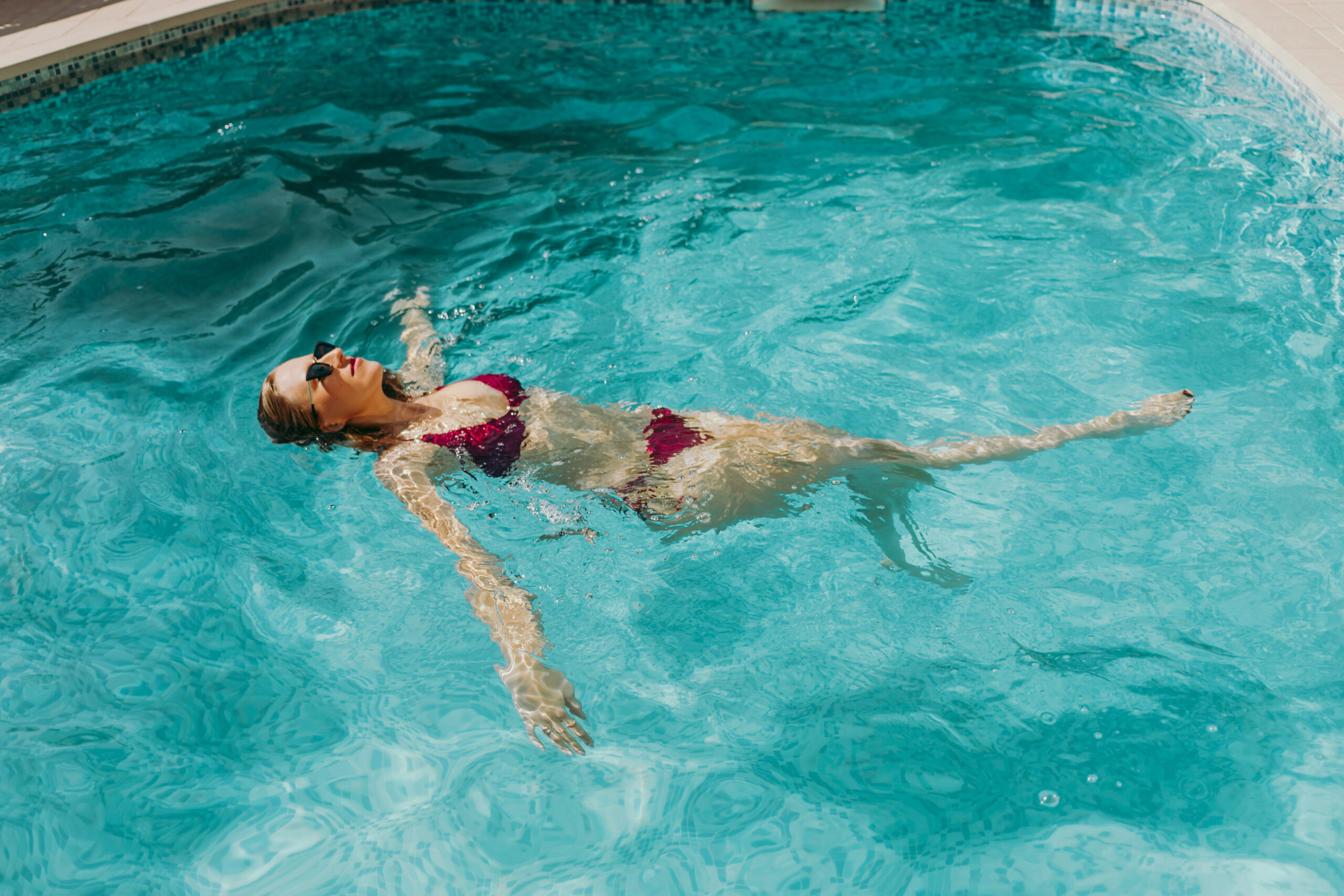 Girl swimming alone in pool content.