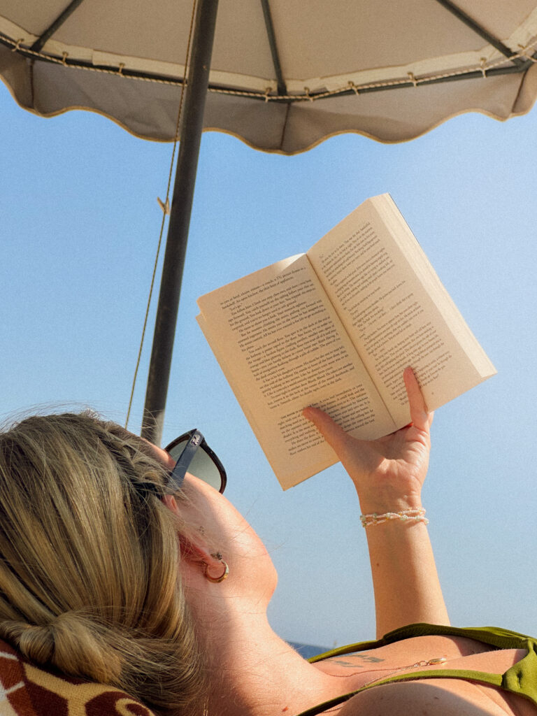Woman reading alone on the beach by herself.