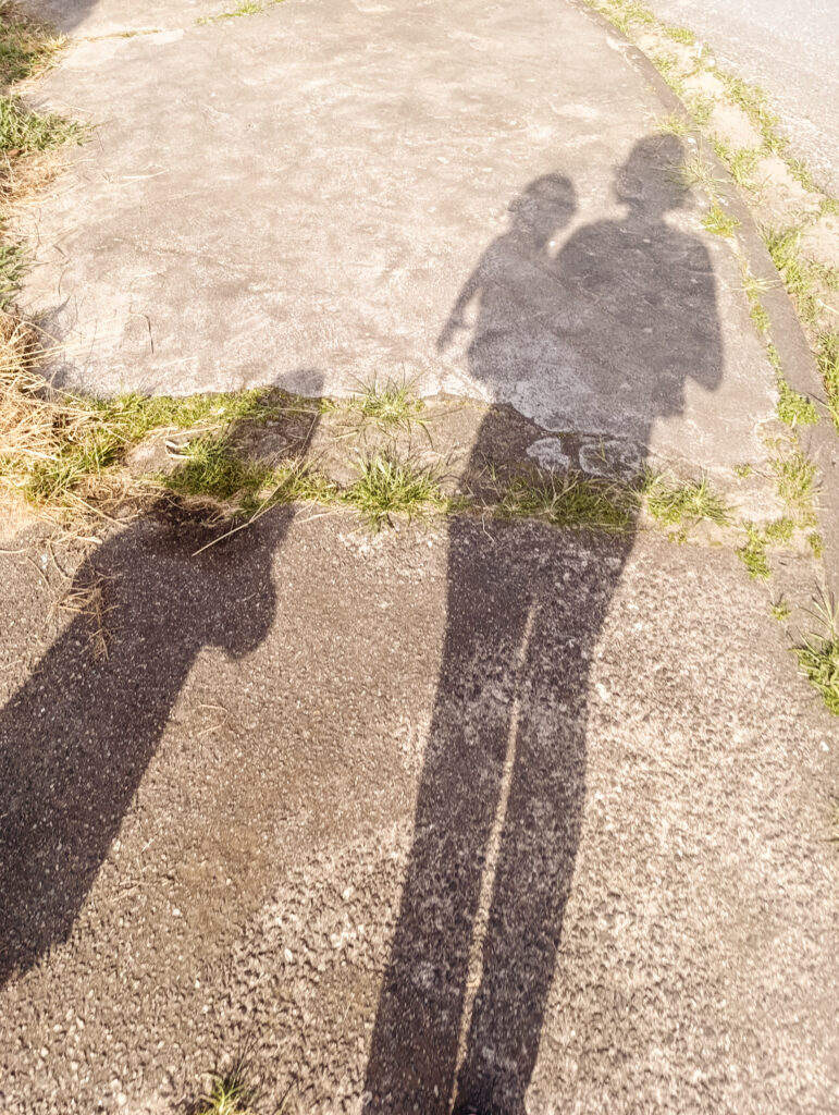 Shadow of parents and child in the ground.