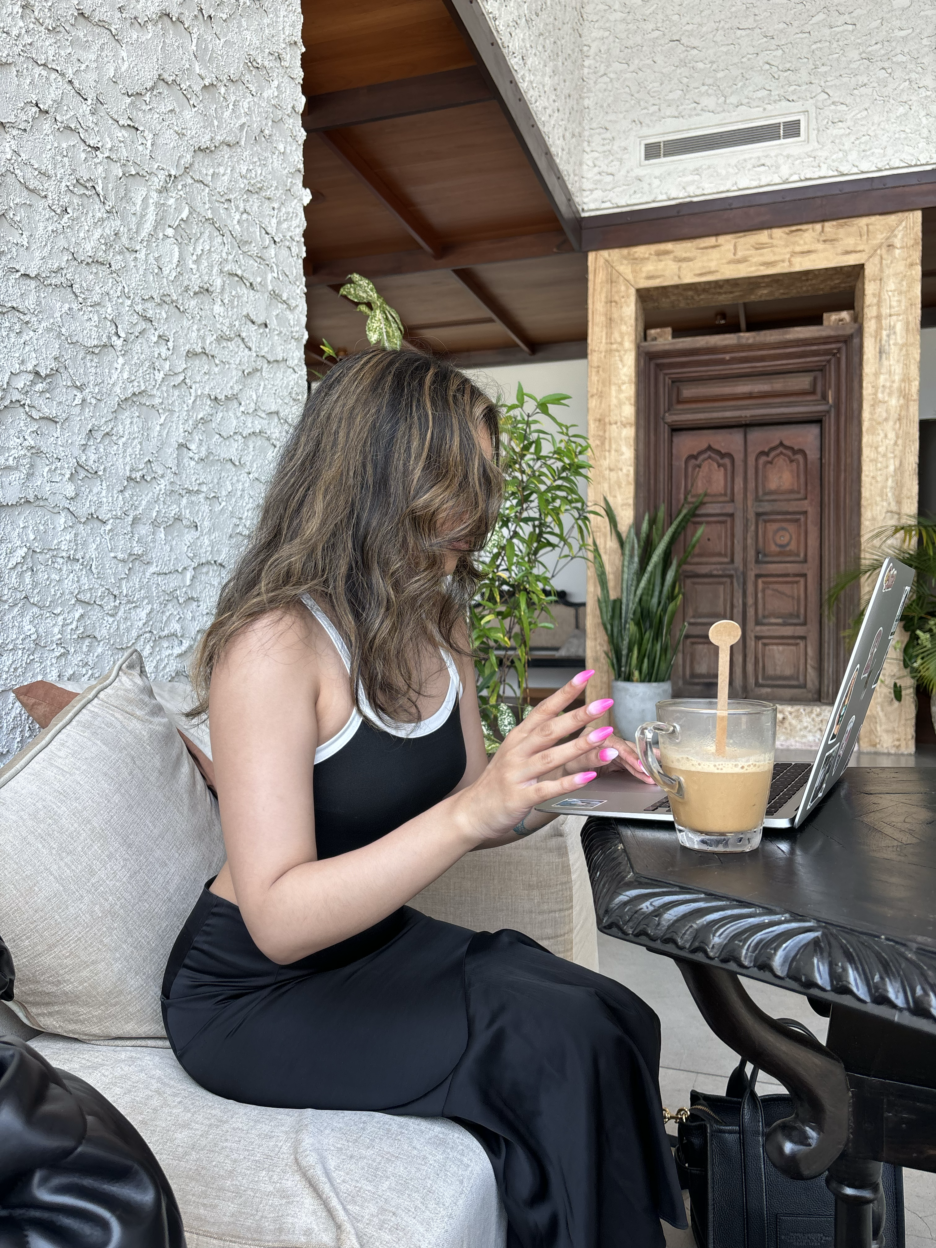Woman working on her computer and drinking coffee.