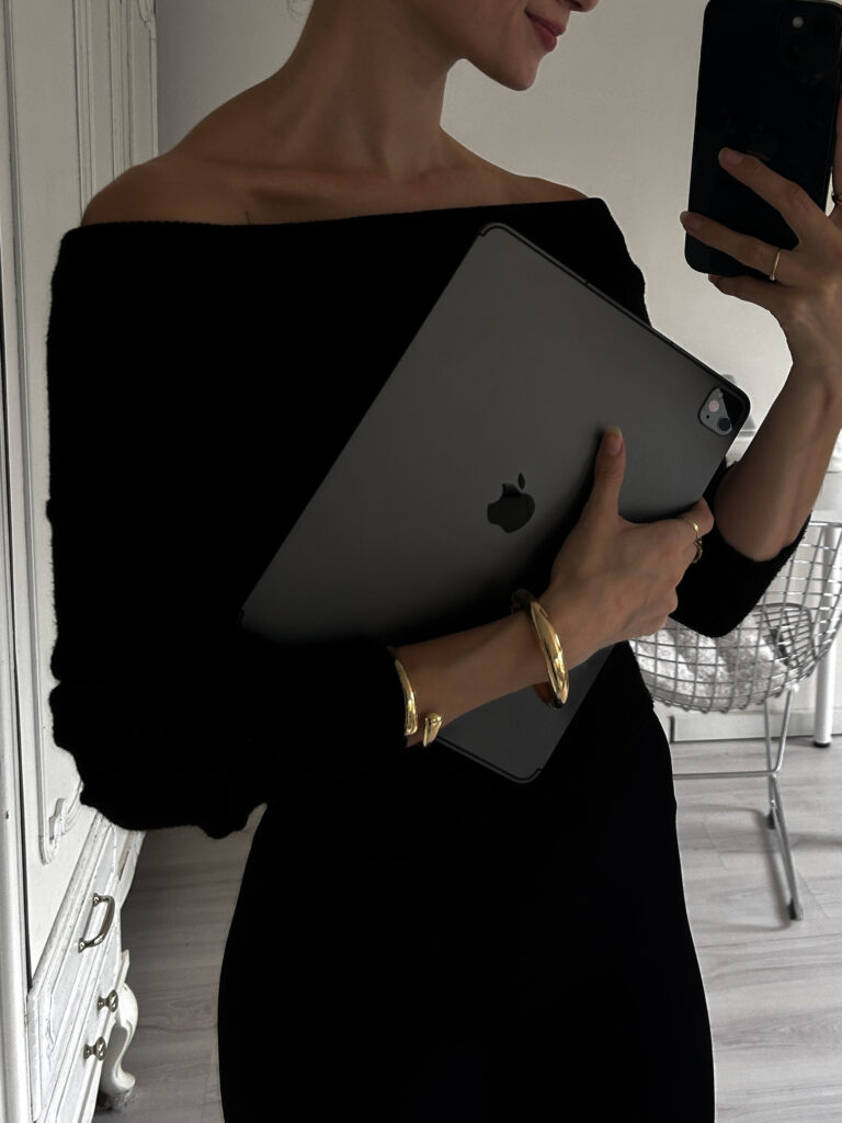 Woman taking a mirror picture with her computer in arms.