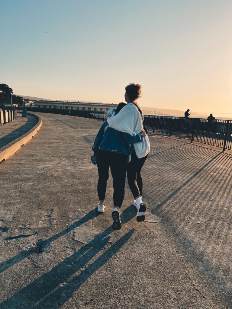 Friends walking and hugging each other.