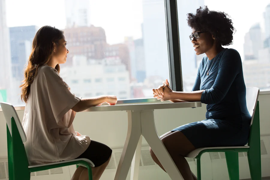Two women talking together at a table.